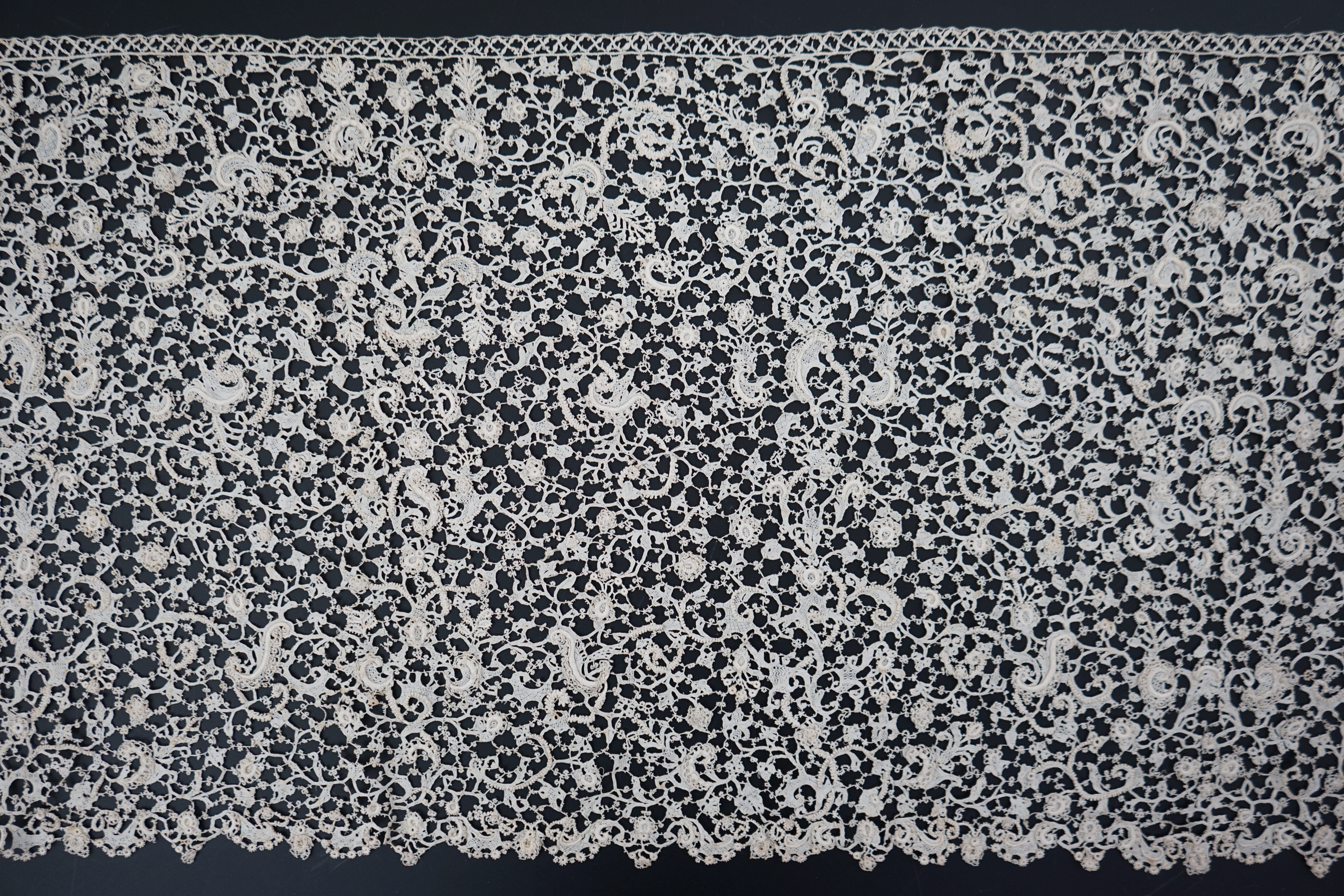 A rare 1680 (360cm length x 28cm deep) flounce of Point de neige, being an elaborate finely raised Venetian needle-point lace, a scaled down version of gros point, this flounce worked into tiny floral and leaf shapes, jo